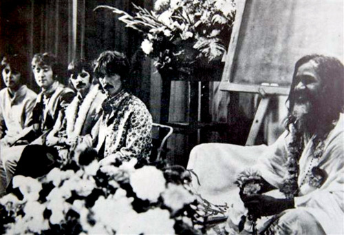 The four Beatles on stage with Maharishi.